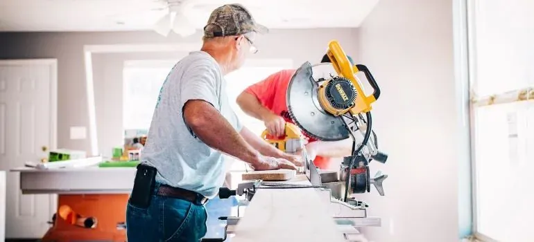 Carpenters using miter saw indoors
