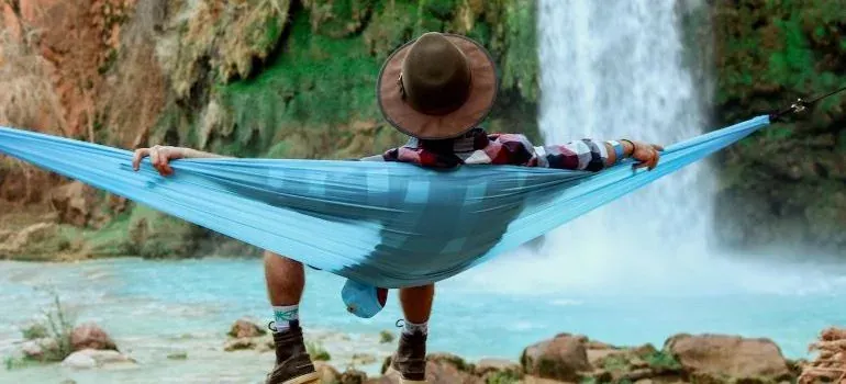 Man in hammock by waterfall