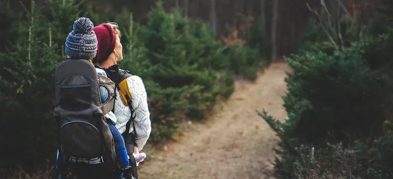 Parent with child carrier on trail