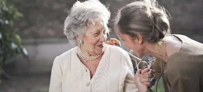 Elderly woman and younger woman laughing together outdoors