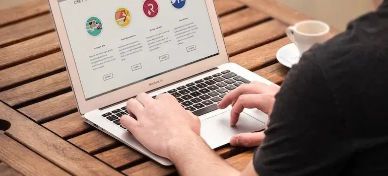 Man browsing generic website on laptop at wooden table