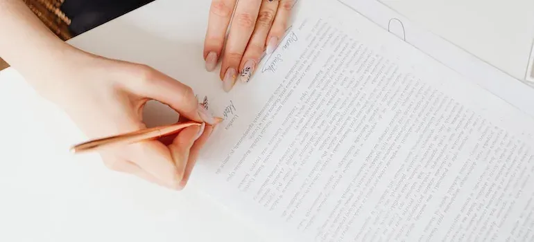 Hands signing document with pen