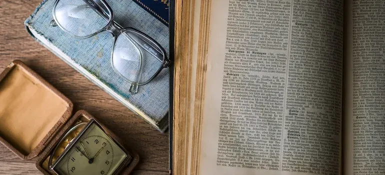 Old book, glasses, vintage clock