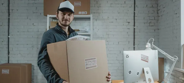 Warehouse worker holding fragile-labeled box