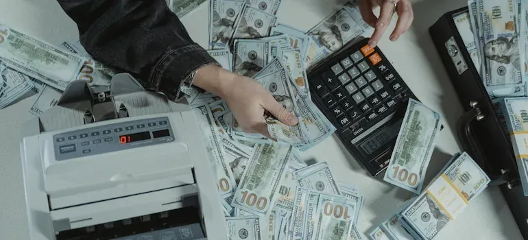 Money counter, calculator, scattered dollar bills
