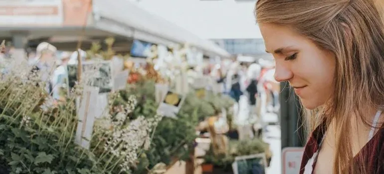 Woman browsing outdoor flower market stalls