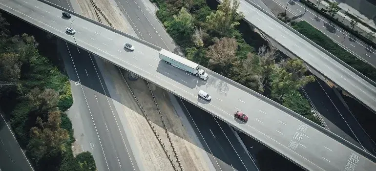 Aerial view of unmarked white semi truck on highway overpass