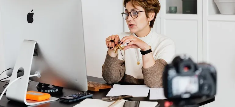 Woman recording video at desk computer