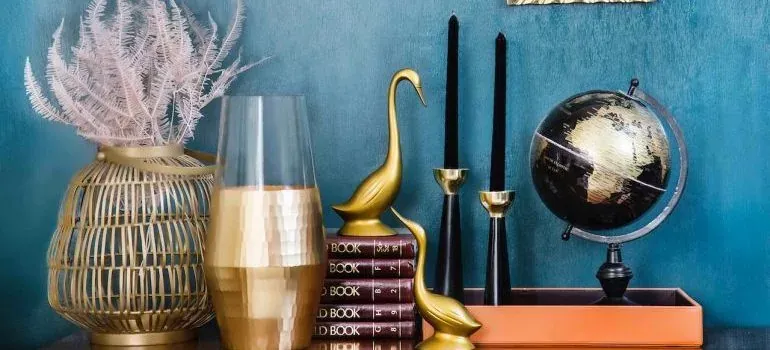 Gold decor items on teal shelf