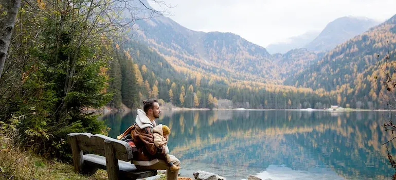 Man on bench by mountain lake