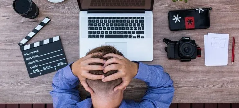 Frustrated man head in hands at laptop