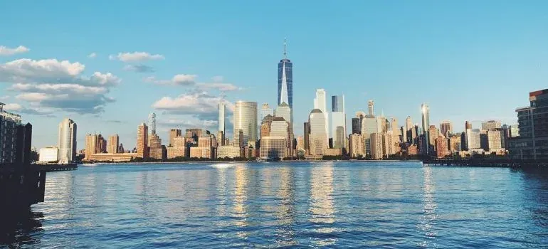 Manhattan skyline across water at sunset