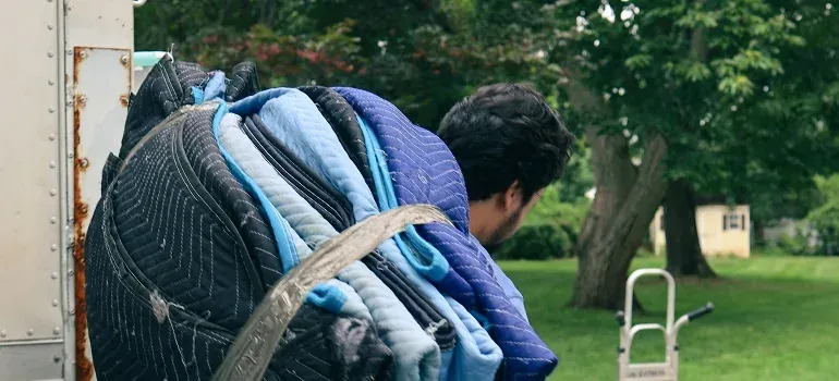 Mover carrying moving blankets by truck