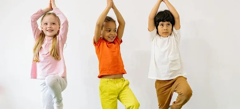 Three children doing yoga poses