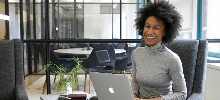 Smiling woman with laptop in office