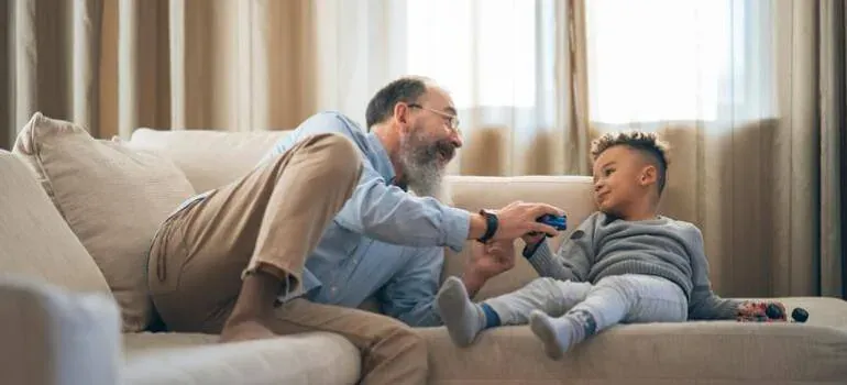 Grandfather playing with boy on couch