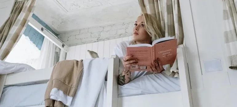 Woman reading book on bunk bed