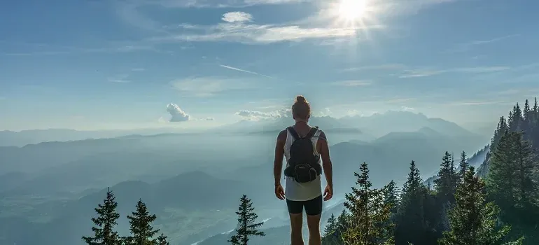 Hiker overlooking mountain valley at sunrise