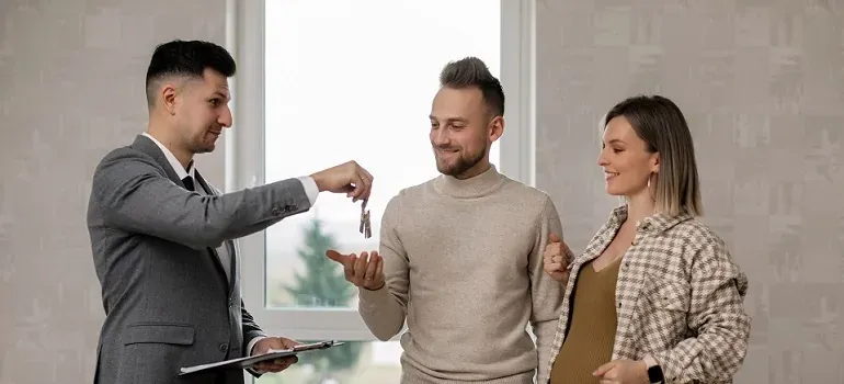 Agent handing keys to young couple