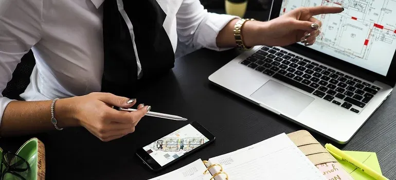 Woman with laptop, phone, floor plans