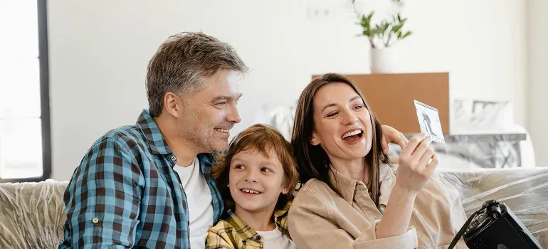 Family laughing on couch during move