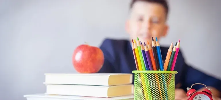 School supplies, pencils, apple, boy blurred