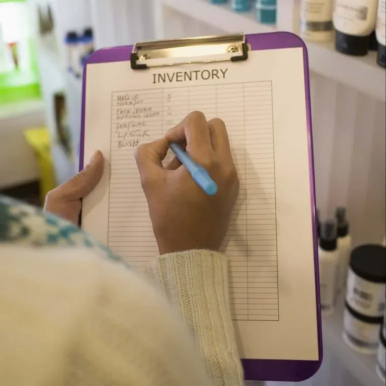 Person writing a moving inventory checklist before a move
