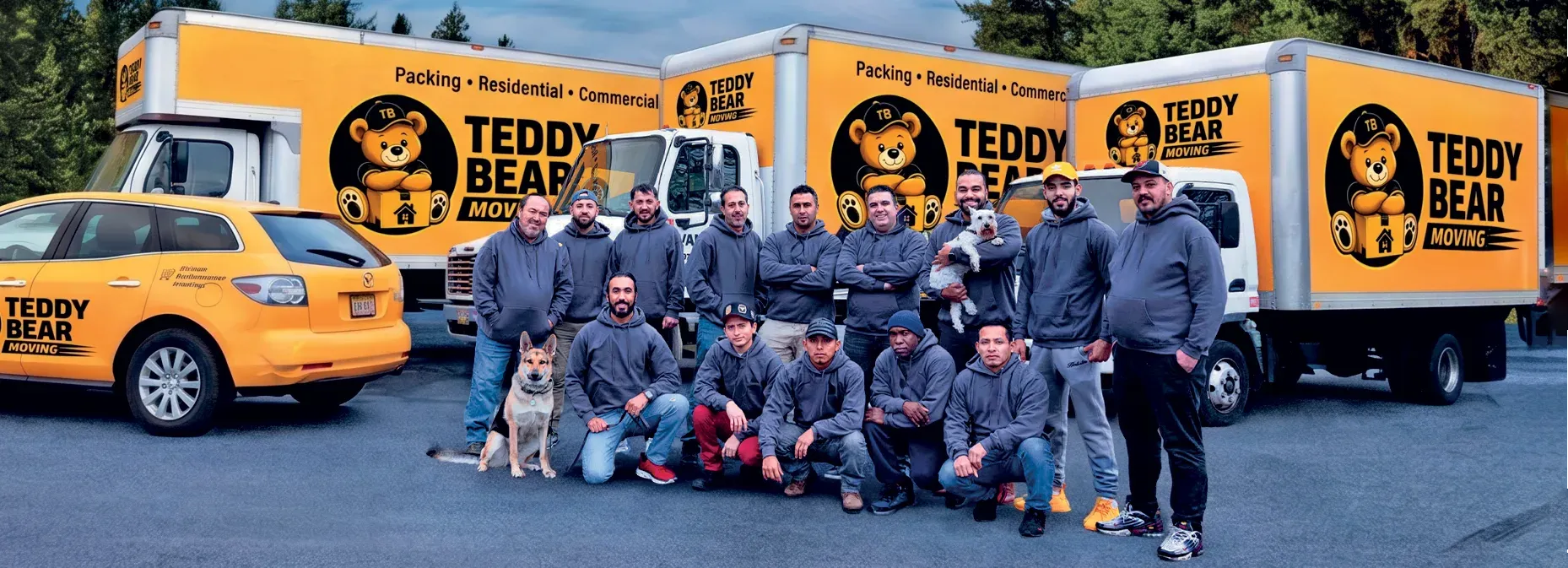 The Teddy Bear Moving crew with their dogs, standing in front of branded Teddy Bear Moving trucks