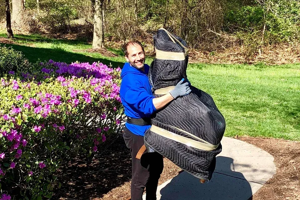 A college student carrying moving boxes into a New Jersey apartment