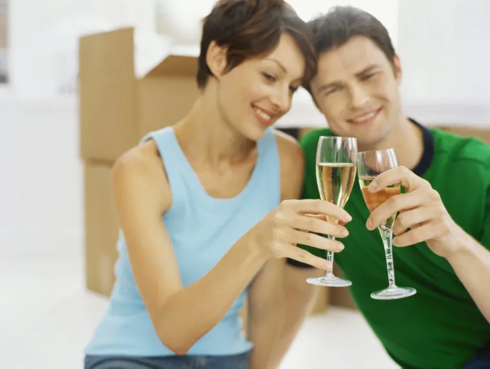 Couple toasting champagne near moving boxes